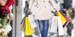 47282061 - woman walking with shopping bags with christmas background.