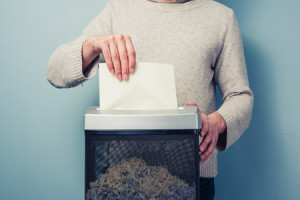 25910937 - man is shredding a piece of paper