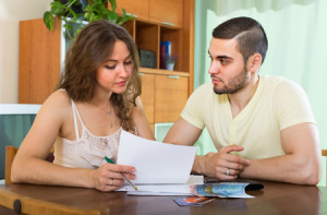 39714249 - young couple sitting at the table and calculating the family budget